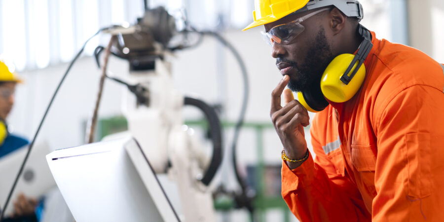 portrait of native american engineer technician wearing safty uniform hand contril automation robot arm welding machine with laptop industrial 4.0 factory background concept Engineering Courses List in Nigeria Types of Engineering